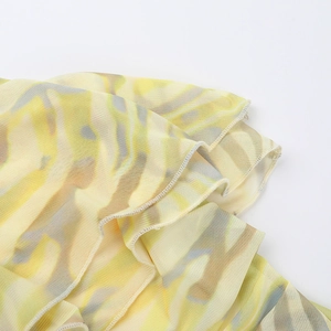 Detail of yellow marble print mesh fabric showing delicate semi-transparent knit texture