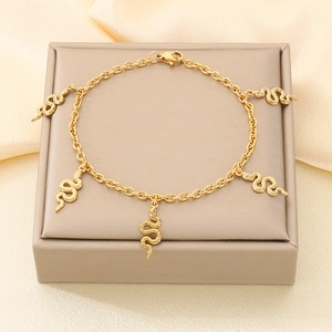 Vue détaillée du bracelet serpent doré avec cinq pendentifs sur un présentoir de luxe