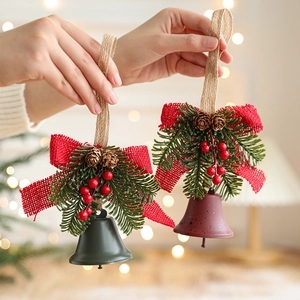 Christmas metal bells with red bows, pine cones and berries for festive door decoration