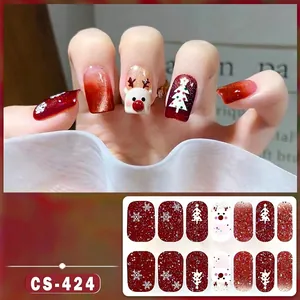 Detail of Christmas nail stickers with reindeer and tree patterns in red cat eye style