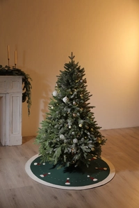 Détail du tapis de sapin de Noël tricoté vert foncé avec motifs de bonnets rouges