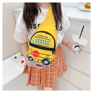 Detail view of yellow school bus cartoon crossbody bag on a child model