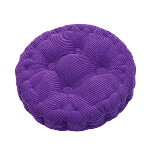 Detail of round purple corduroy chair cushion with thick ribbed texture and tufted center