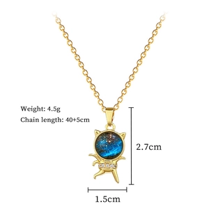 Detail of gold cat pendant with starry blue pattern and crystals on a titanium chain