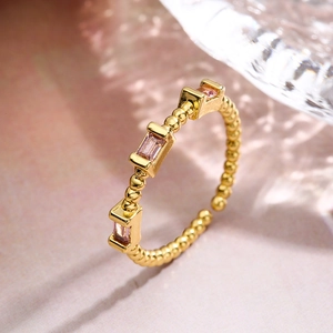 Gold plated beaded ring featuring three rectangular pink zircons in an open design