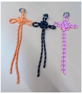 Three handmade paracord keychains in orange, black, and pink with metal ring detail