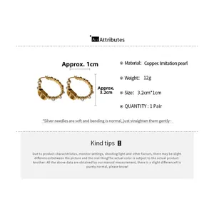 Detail view of gold pig nose earrings with white pearls and 3.2cm length specifications