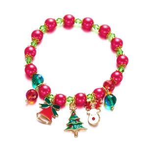 Detail of Christmas bracelet with red pearls, green beads, bell, and deer charms