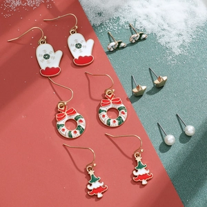 Detailed flat lay of Christmas earring set with snowman, wreath, and candy cane designs