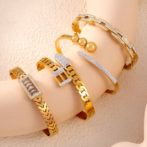 Set of 5 gold titanium steel chain bracelets with hollow diamond accents on beige stand