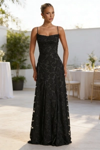 Detail of the black textured jacquard fabric on a slim fit maxi dress with spaghetti straps