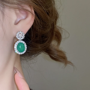 Gros plan de boucles d'oreilles en argent avec calcédoine verte et fleurs en zircon