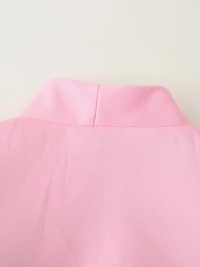 Dettaglio macro della trama del tessuto e cuciture sullo scollo del blazer rosa a maniche corte
