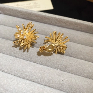 Detailed view of 18K gold plated zircon firework clip-on earrings on gray velvet