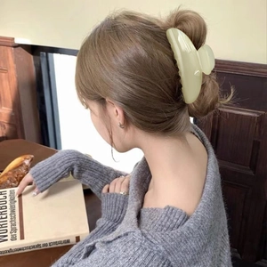 Elegant cream semi-circle hair claw clip for women shown in a cozy indoor lifestyle setting