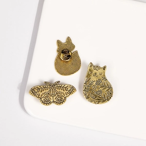 Détails de broches vintage en bronze avec motifs de chat et papillon gravures florales