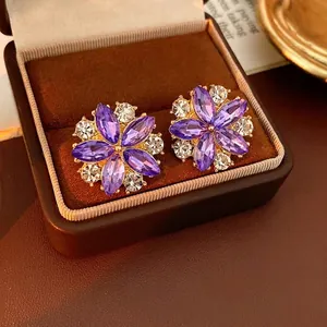 Orecchini a fiore vintage in oro con gemme viola e diamanti in un astuccio di velluto