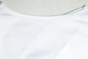 Detailed view of the double-needle stitched neckline on a white sleeveless dress