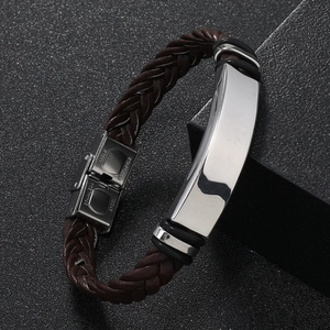 Detail of men's brown braided leather bracelet with a polished stainless steel buckle