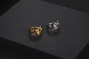 Close-up of lightning-shaped stainless steel rings in gold and silver polished finish