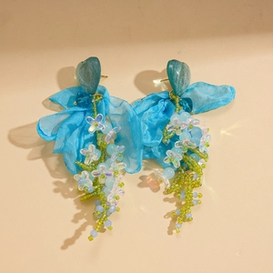 Detail showing blue heart resin studs with chiffon bows and long beaded tassels
