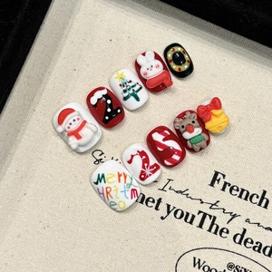 Handmade 3D relief Christmas press-on nails featuring snowman and tree on canvas board