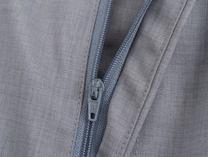 Détail du tissu gris et de la fermeture éclair en nylon avec le logo CHE gravé