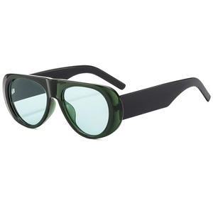 Detail view of oversized retro sunglasses with deep green frames and light blue lenses