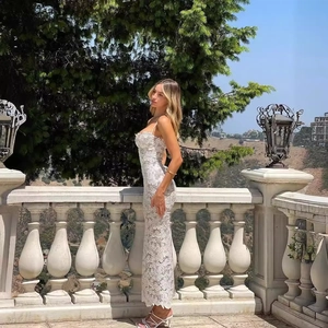 Robe longue élégante en dentelle blanche avec coupe ajustée sur un balcon