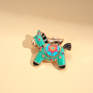 Detailed macro of a green enamel horse brooch with floral saddle and golden ingot details