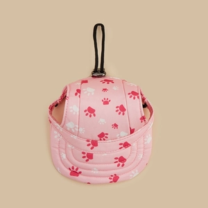 Dettaglio del berretto rosa per cani con stampe di zampe e cinturino regolabile