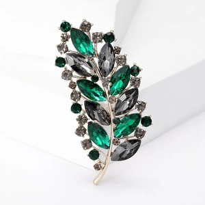 Elegant crystal leaf brooch with green and smoke gray stones on a gold alloy base