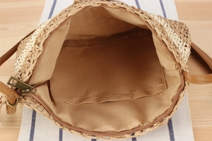 Détail du sac en paille montrant la doublure, la poche plaquée et la fermeture éclair bronze