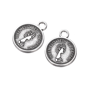 Detailed close-up of antique silver coin charms featuring Queen Elizabeth II portraits