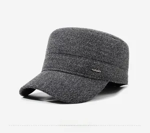 Detail view of thick grey wool flat cap featuring a decorative metal Donatella side plaque
