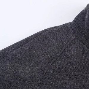 Close-up of high-quality dark grey wool coat fabric with precise stitching details
