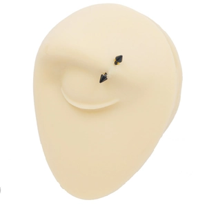 Close-up of black spiked eyebrow ring on a realistic silicone eye training model