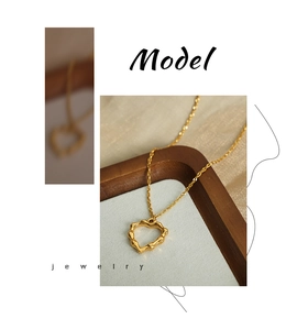 Vue détaillée d'un pendentif cœur doré avec texture bambou sur une chaîne délicate