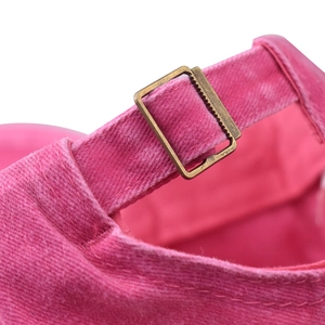 Detail of rose pink washed cotton baseball cap with adjustable metal buckle and stitching