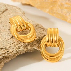 18k gold plated stainless steel twisted hoop earrings displayed on a natural stone block