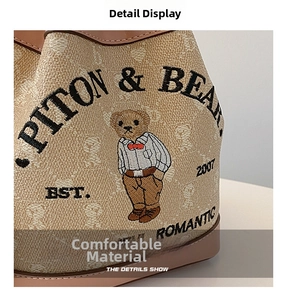 Macro detail of bucket bag showing bear embroidery and textured pebble leather material