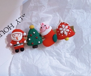 Detail of cute resin Santa and Christmas tree hair clips on white textured background