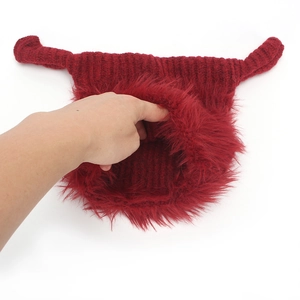 Detail of red knit hat featuring warm plush lining and funny horn design details