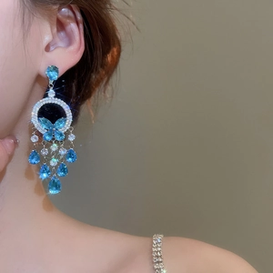 Close-up of elegant blue zircon butterfly tassel earrings with sparkling rhinestones