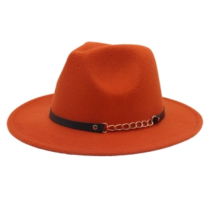 Detail of orange wool felt fedora with black leather band and golden chain accents