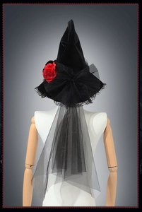 Detail of black velvet witch hat with red roses, lace trim and long mesh veil
