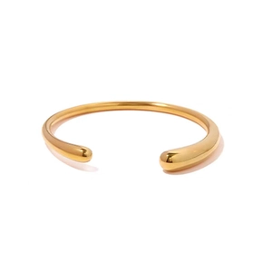 Vue détaillée du bracelet doré ouvert avec bouts en forme de goutte et fini poli