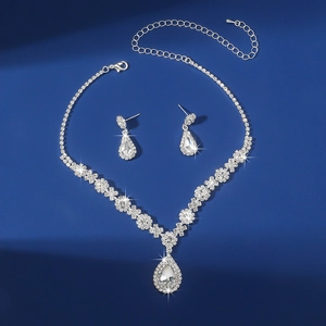 Detailed view of teardrop rhinestone necklace and matching silver earrings set