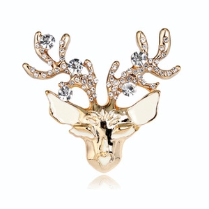 Detail of a golden reindeer head brooch with white enamel and sparkling rhinestones