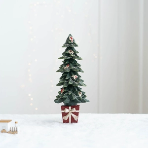 Détail d'un mini sapin de Noël sur socle boîte cadeau rouge avec un nœud doré élégant